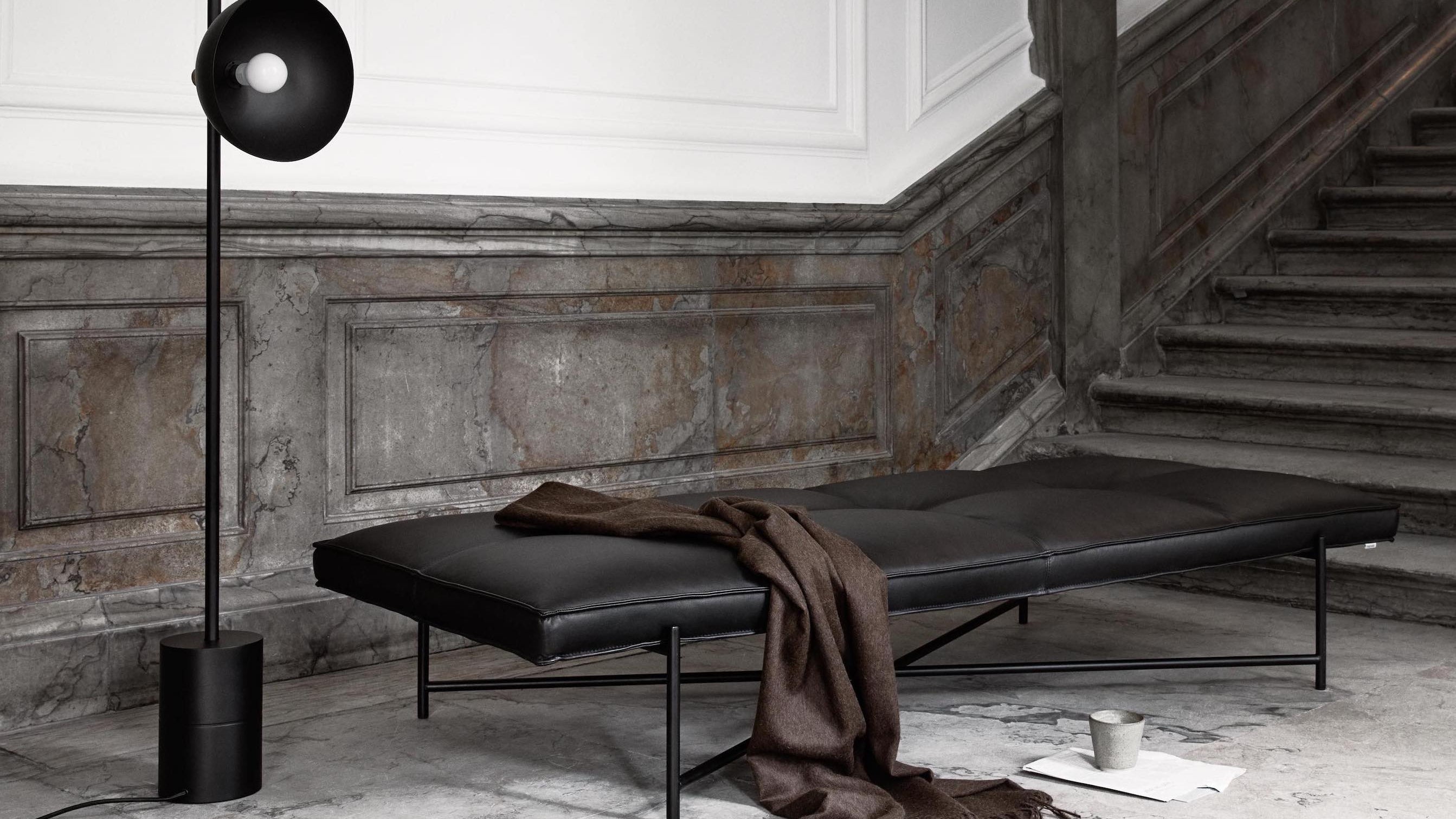 Leather-upholstered HANDVÄRK daybed with a black powder-coated metal frame.